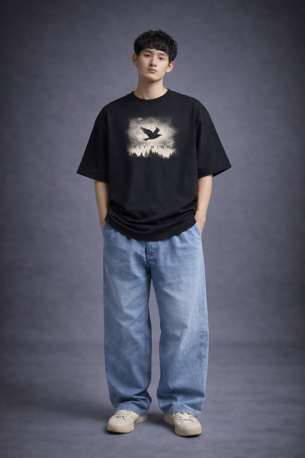 Person wearing a black t-shirt with a graphic design and blue jeans on a gray background
